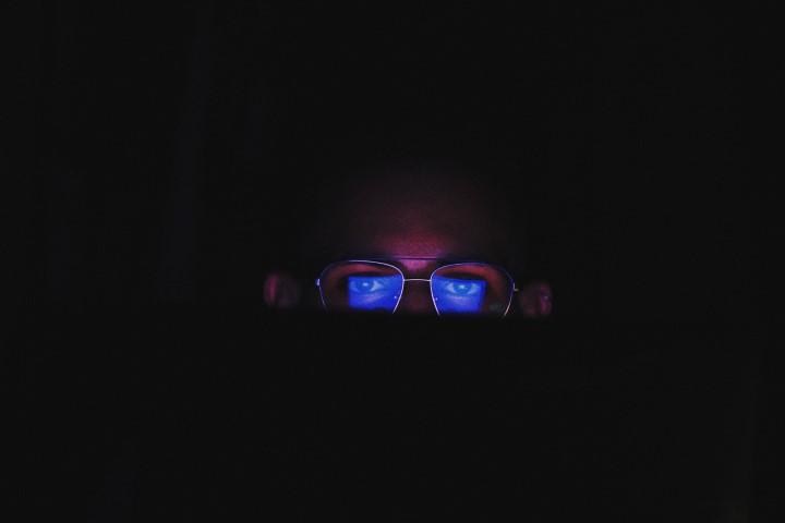 blue light reflecting off a guys glasses