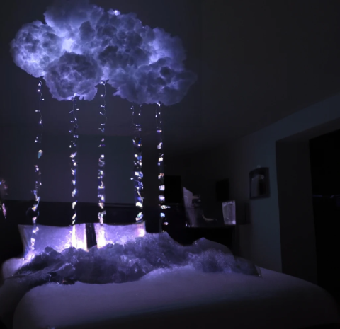 led cloud lit up by strings of lights in a dark room