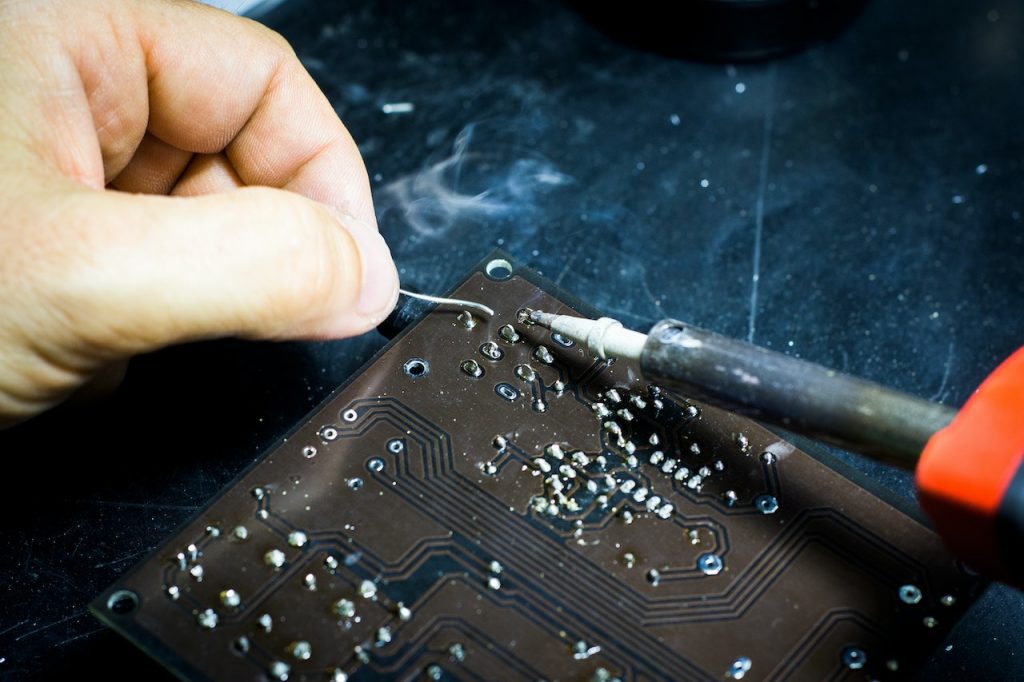 close up on someone soldering a circuit board